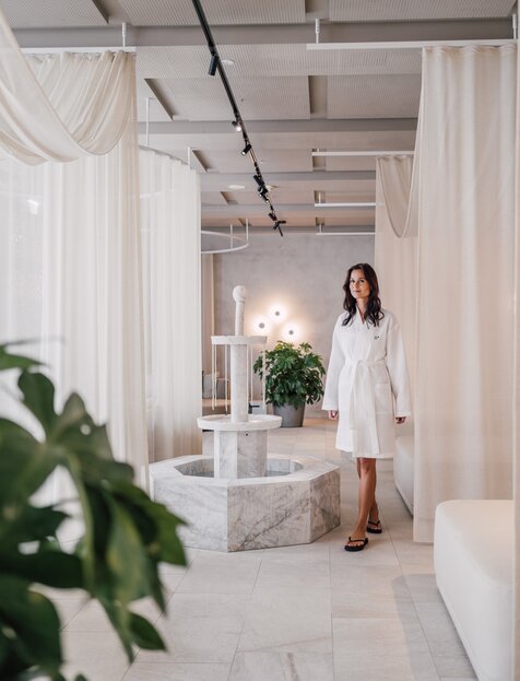 Frau in weißem Bademantel im eleganten SPAplus Ruheraum | © Spa Resort Geinberg / Chris Perkles