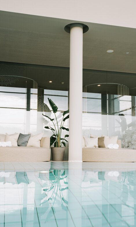 Heller Spa-Bereich mit Indoor-Pool und bequemen Liegebereichen mit Designer-Daybeds | © Spa Resort Geinberg / Tobi Gast