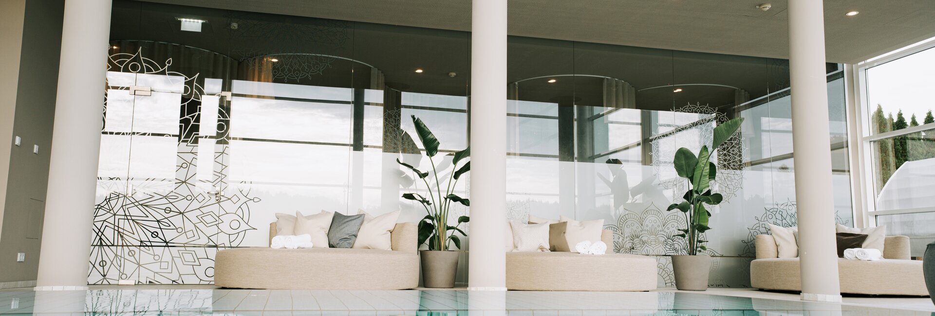 Heller Spa-Bereich mit Indoor-Pool und bequemen Liegebereichen mit Designer-Daybeds | © Spa Resort Geinberg / Tobi Gast