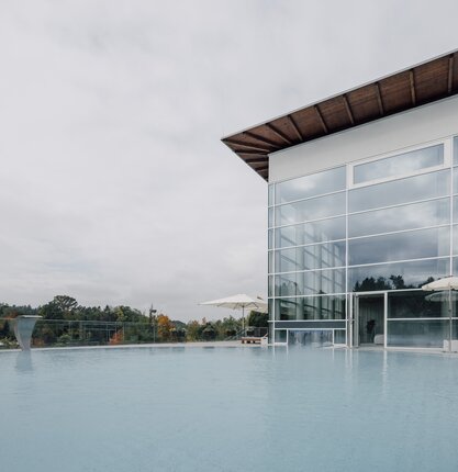 Ansicht des Außenpools mit Sicht auf das Gebäude des Spa Resort Geinberg | © Spa Resort Geinberg / Chris Perkles