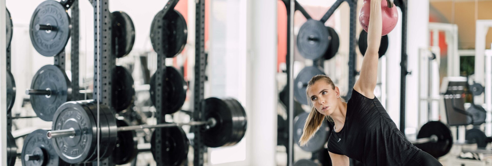 Sportliche Frau trainiert mit Kettlebells im Fitness Center des Spa Resort Geinberg | © Spa Resort Geinberg / Chris Perkles