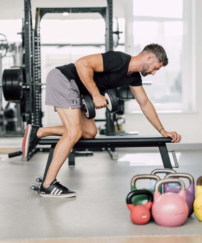 Mann trainiert mit Hanteln im Kraftbereich des Fitness Centers im Spa Resort Geinberg | © Spa Resort Geinberg / Chris Perkles