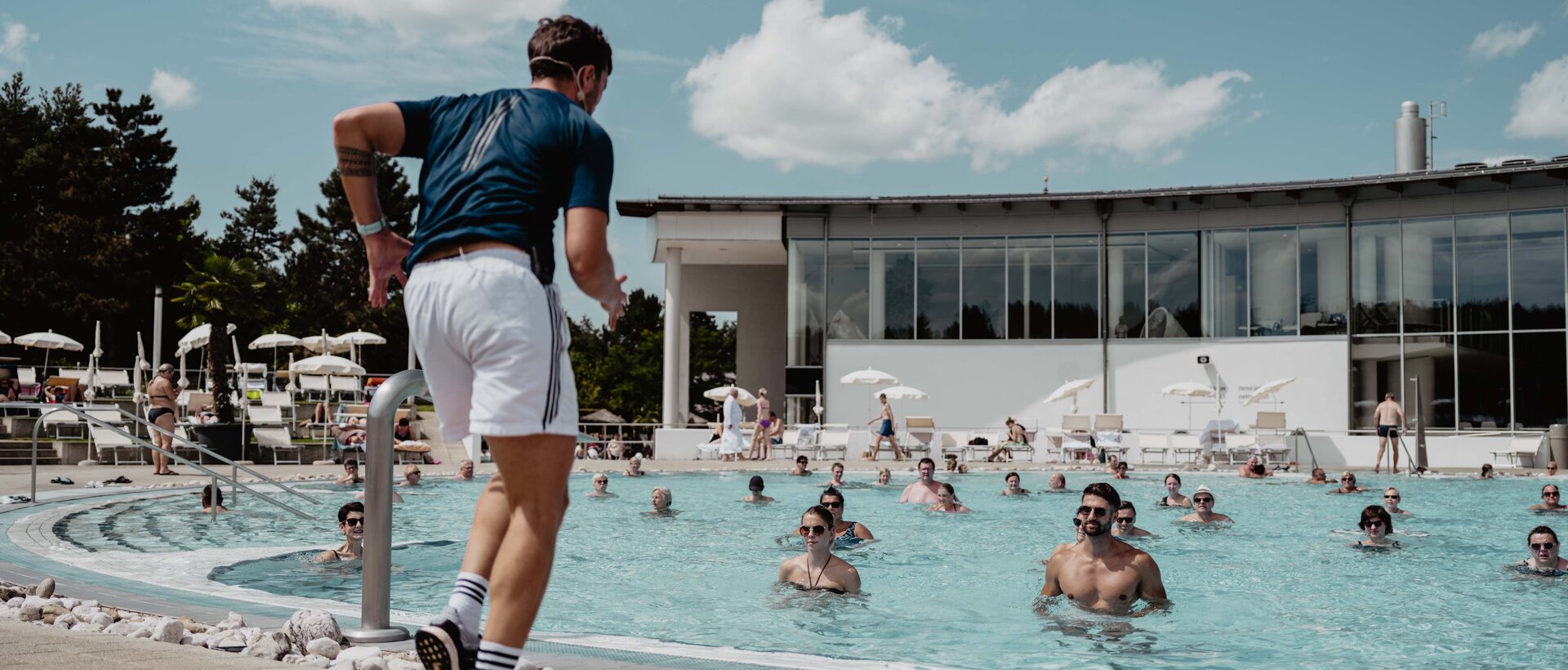 Trainer und engagierte Teilnehmer beim Sportkurs Aqua Fitness im Thermal-Becken outdoor der Therme Geinberg | © Spa Resort Geinberg / Chris Perkles