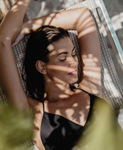 Entspannte Frau auf Liegestuhl im Schatten