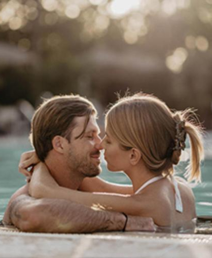 Romantisches Paar im Pool bei Abendsonne