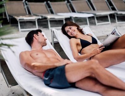 Lächelndes Paar entspannt auf Sonnenliegen