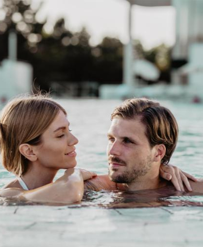 Glückliches Paar im Pool bei Sonnenuntergang