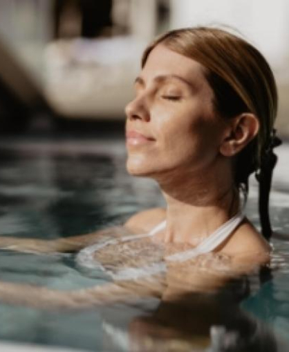 Entspannte Frau im Pool mit geschlossenen Augen