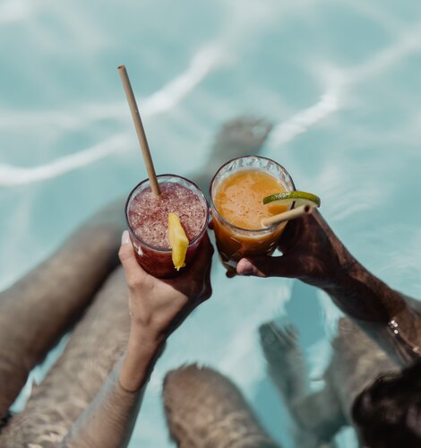 Zwei Personen genießen ihren fruchtigen Cocktail im Pool der Karibik-Lagune im Spa Resort Geinberg | © Spa Resort Geinberg / Chris Perkles