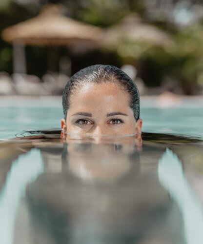 Frau im Wasser, nur Gesicht und Schultern sichtbar | © Spa Resort Geinberg / Chris Perkles