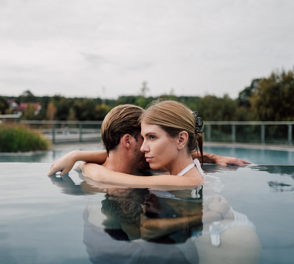 Paar entspannt bei Umarmung im Kaskaden-Becken im Spa Resort Geinberg  | © Spa Resort Geinberg / Chris Perkles
