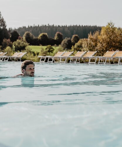Mann schwimmt im Sportbecken des Spa Resort Geinberg im Herbst