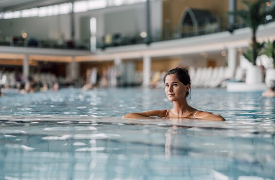 Frau genießt das Thermalwasser im Innenbereich der Therme Geinberg  | © Spa Resort Geinberg / Chris Perkles