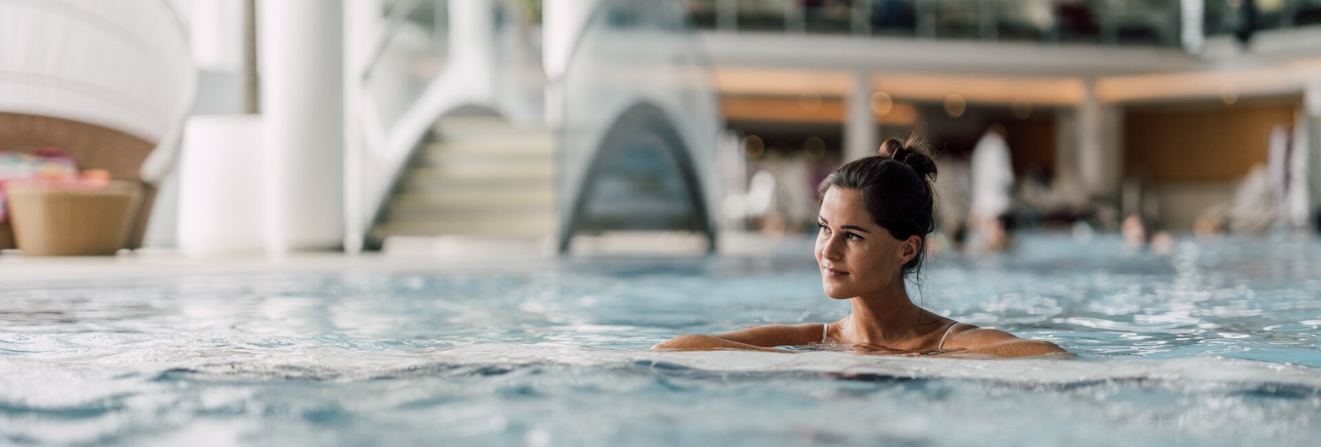 Frau entspannt im wohltuenden Thermalwasser des Thermal-Beckens indoor der Therme Geinberg | © Spa Resort Geinberg / Chris Perkles