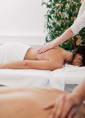 Paarmassage im Spa Resort Geinberg: Frau liegt auf dem Bauch, wird massiert