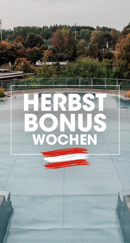 Leeres Thermalbad-Außenbecken umgeben von Herbstlaubbäumen